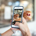 selective focus photography of person taking picture of brown food